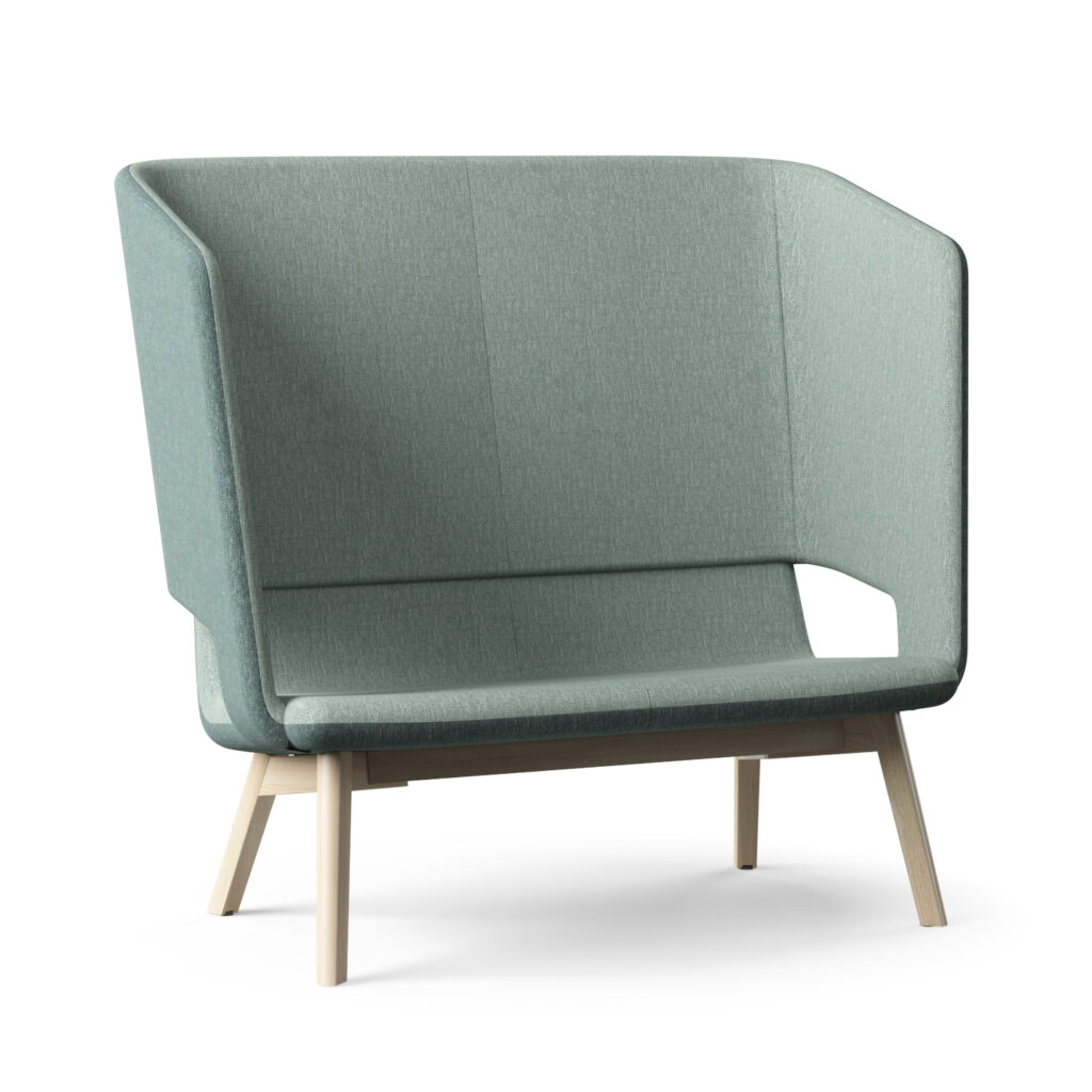 Lysegrøn, betrukket sofa med omsluttende ryglæn og bløde, polstrede flader. Designet har afrundede hjørner, en åben udskæring i den ene side og slanke, lyse træben som kontrast. Overfladen viser fin vævet tekstur, og formen virker minimalistisk og indbydende i et lyst, neutralt miljø.